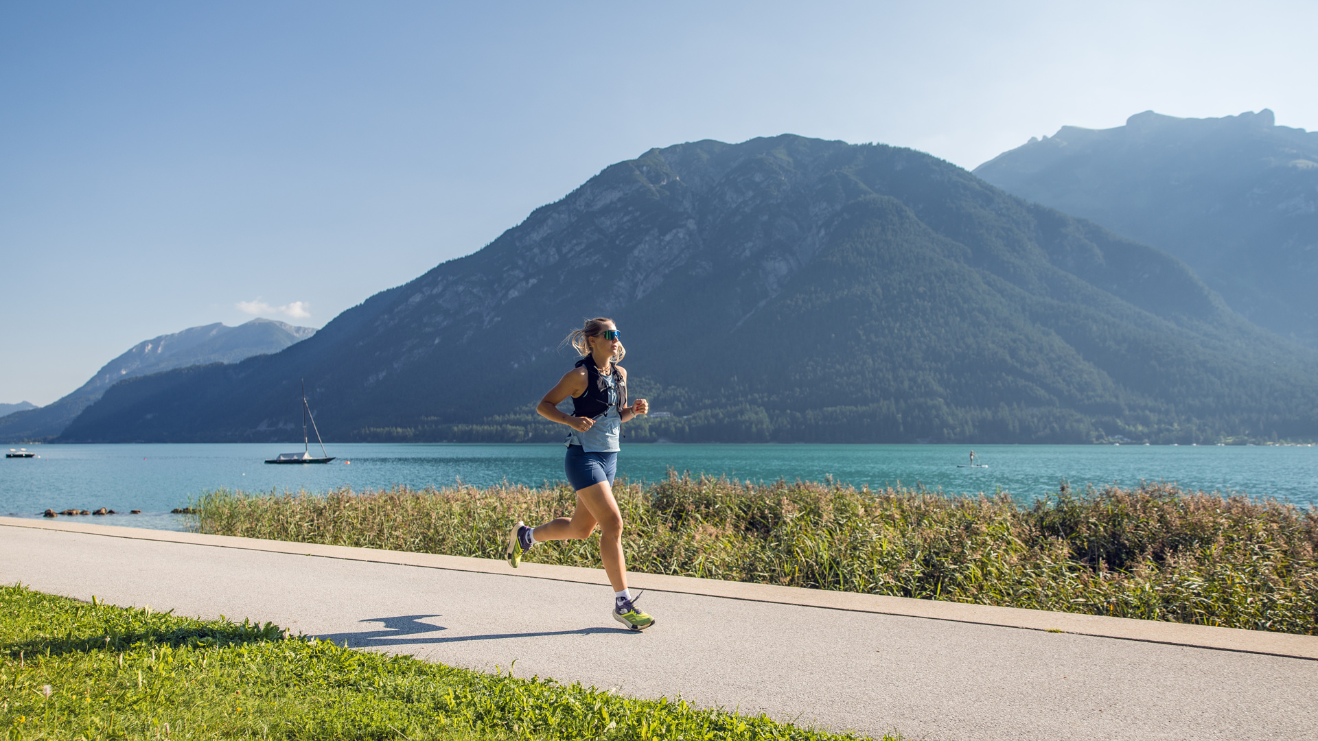 Eine Läuferin ist an der Seeuferpromenade in Pertisau am Achensee unterwegs und nutzt das gute Wetter aus.