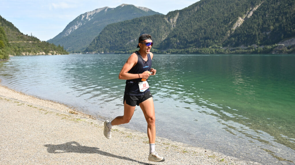 Ein Staffelläufer ist auf der Achenseelauf Eventstrecke unterwegs.